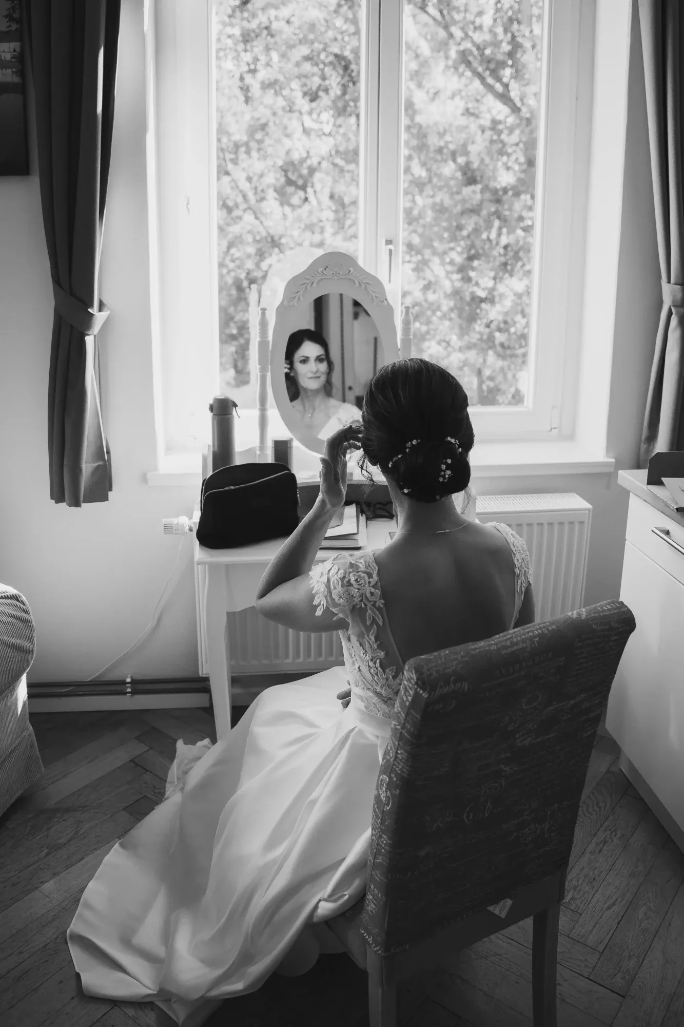 Braut beim Getting Ready am Fenster